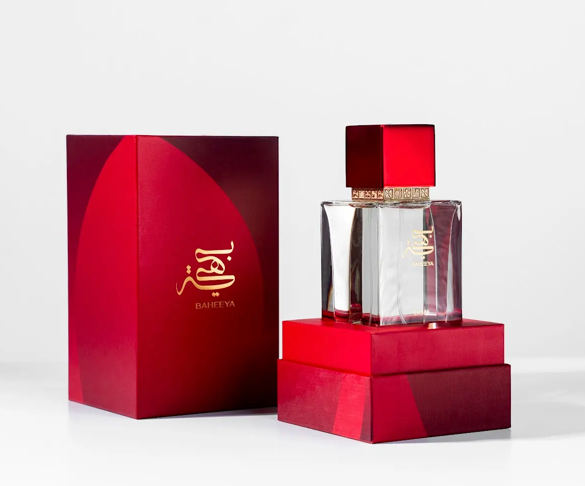 Perfume bottle and packaging with a red and gold design on a white background