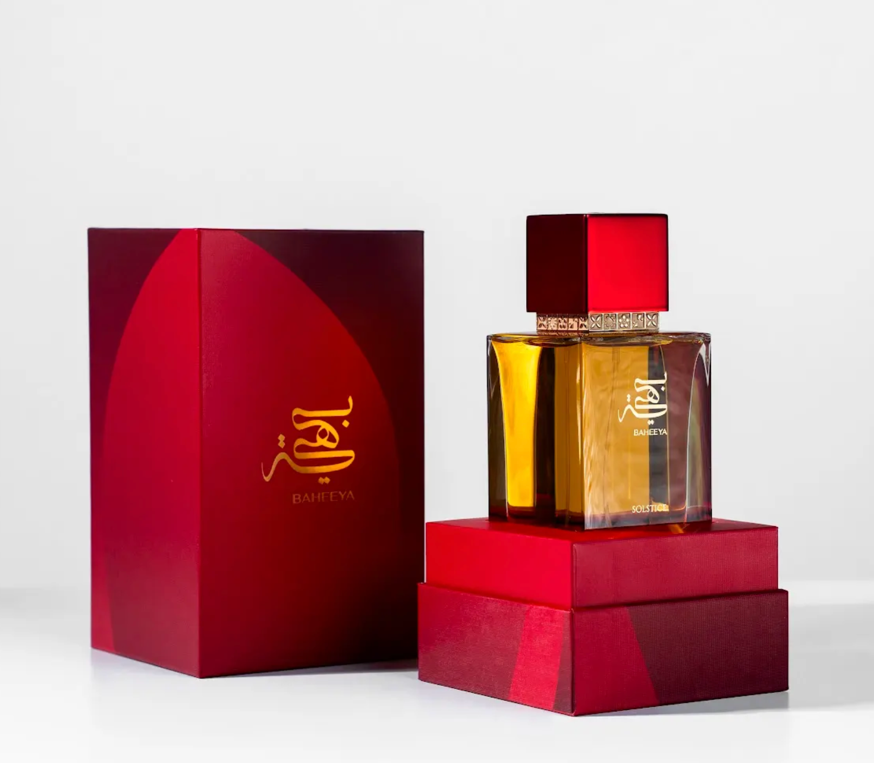 Perfume bottle and packaging with a red and gold design on a white background